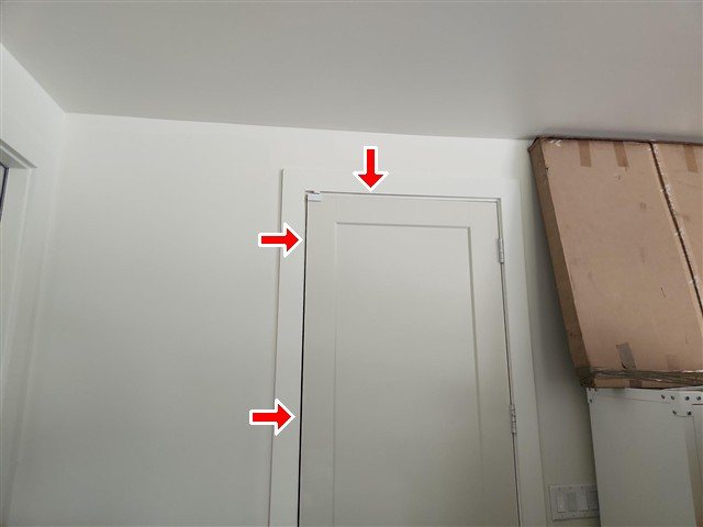 Interior garage-to-house door — air gaps, no door stop, wall hole